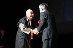 ゴールデングローリー賞を受賞された蟹江敬三さんのプレゼンテーターを務めたあと、記念品を渡す木原秀成理事長